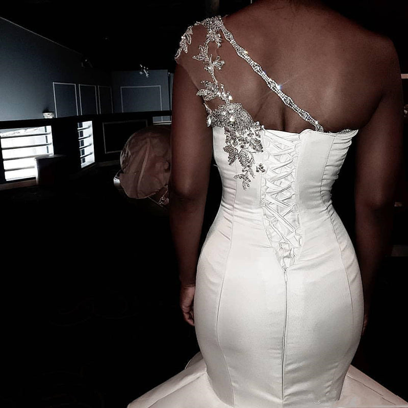 sheer one shoulder wedding dress T262056 Dramatic Stretch Soft Crepe Fit and Flare Gown with One Shoulder Design and Sheer Beaded Embroidery Lace Inset Back and Skirt